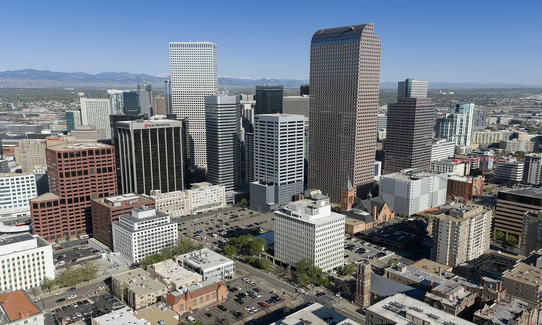 Aerial view of Colorado high-rises with mountains along the distant horizon.