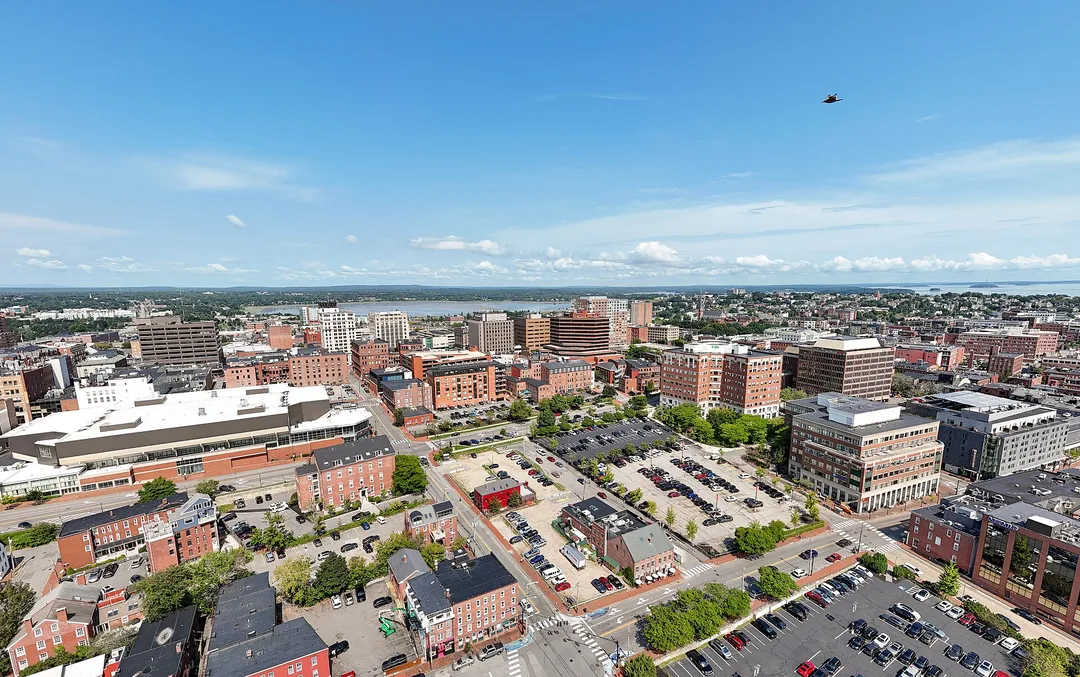 Low-rise brick buildings and intersecting streets fill an aerial view of a Maine city.