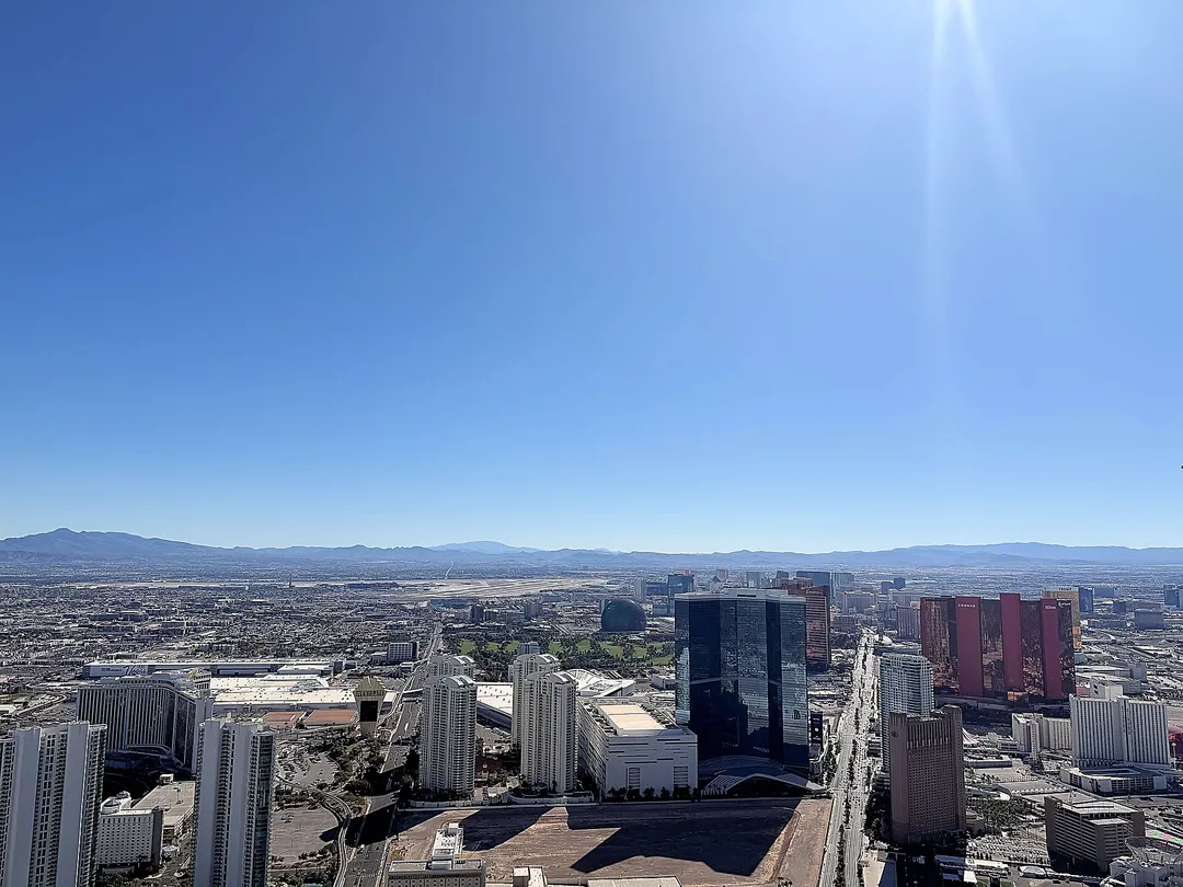 An elevated view of Nevada hotel towers and city streets stretching toward desert mountains.